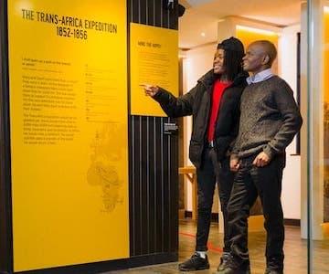 Two visitors exploring the Trans-Africa Expedition display
