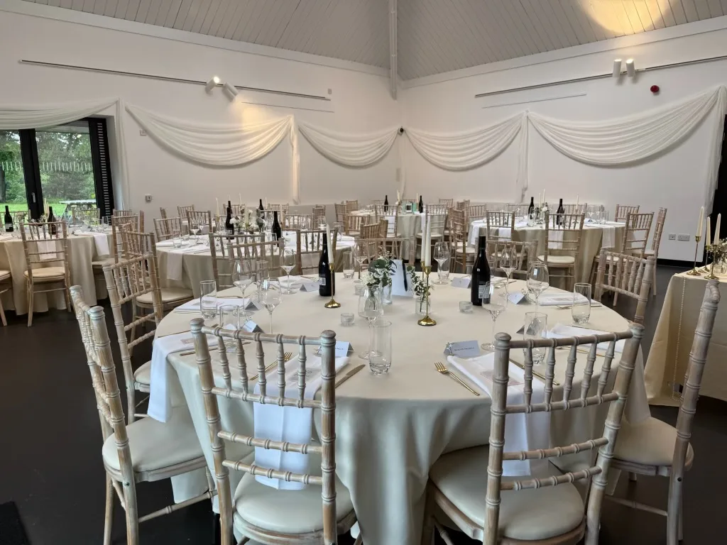 The reception room dressed with round tables, flowers and candles