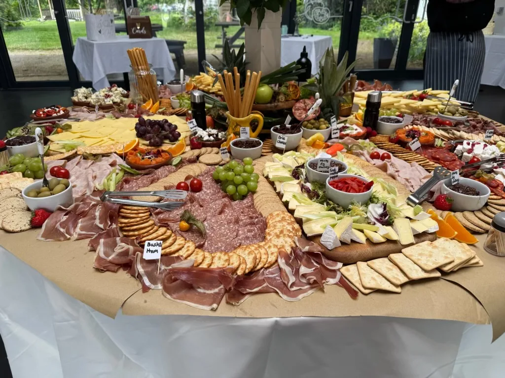 A generous wedding grazing table with cheeses, fruit and charcuterie